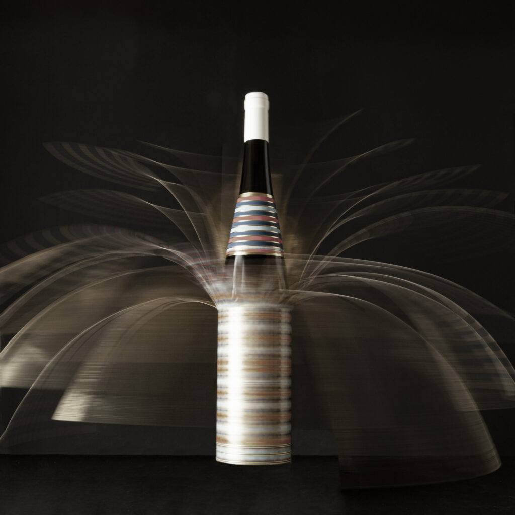 Bottiglia KV62 con packaging second skin aperta in movimento.