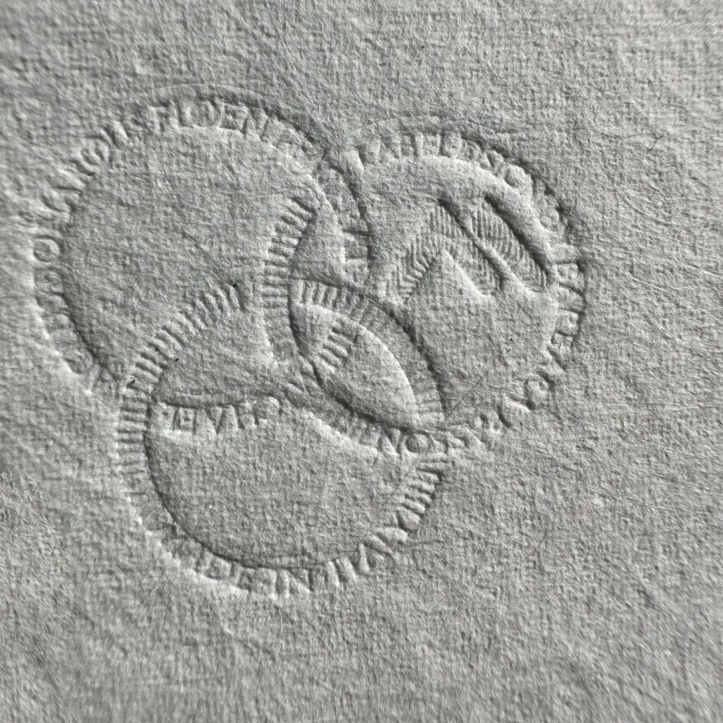 Dettaglio dei tre cerchi impressi sulla linguetta dell’etichetta M63, con microincisioni della firma di Michelangelo, del nome Barbara Passon e della dicitura Made in Italy.