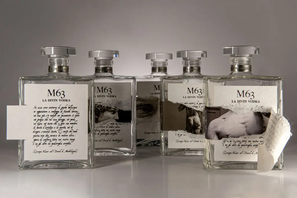 Cinque bottiglie M63 La Divin Vodka, con etichette integre e parzialmente strappate che rivelano diversi particolari del David di Michelangelo.